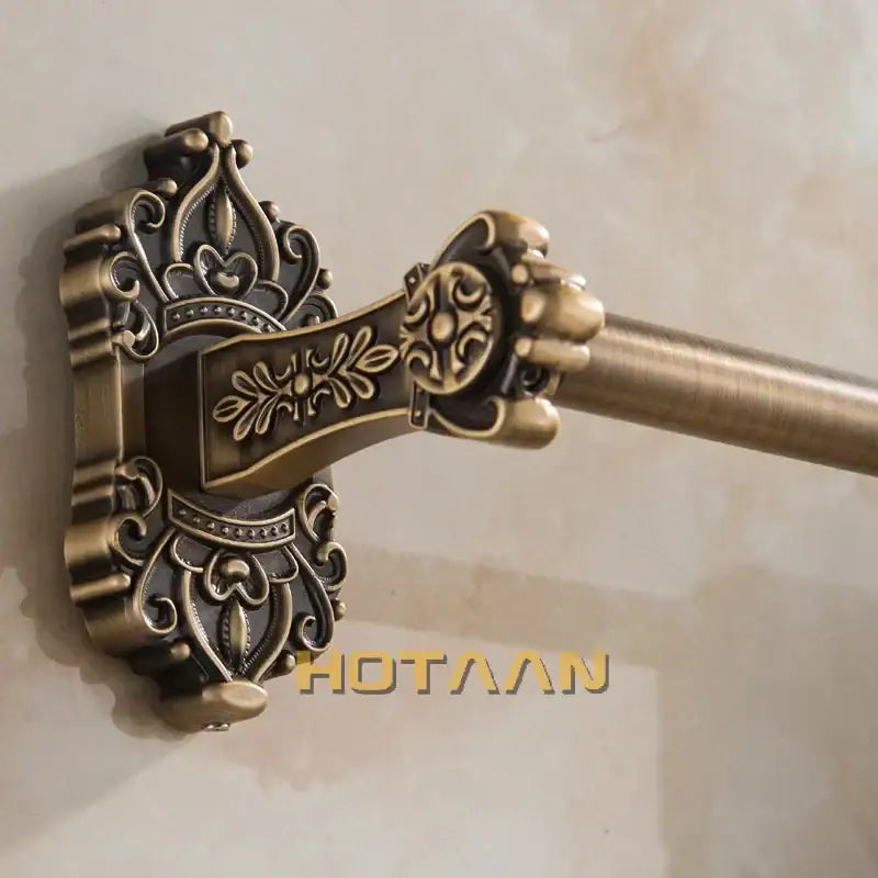 Decorbites antique brass towel bar with ornate scrollwork detailing and sturdy cylindrical brass towel bar design