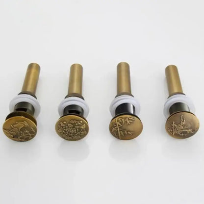 Four brass-finished antique brass vessel sink drain stoppers with engraved floral and bamboo designs for bathroom use