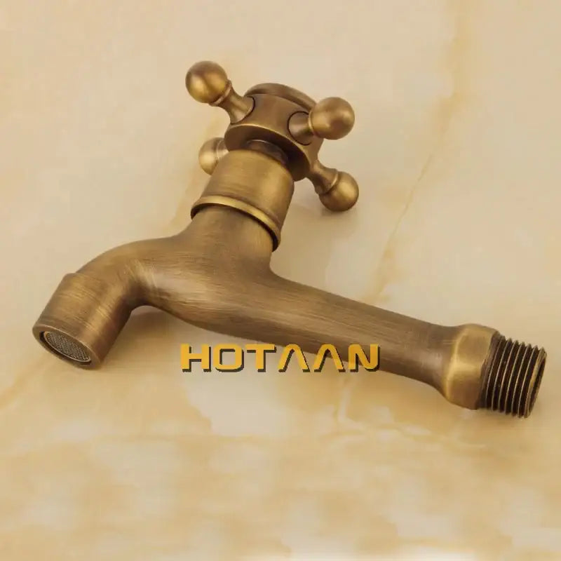 Antique brass wall mount bibcock faucet with cross handle and threaded spout for garden and bathroom use