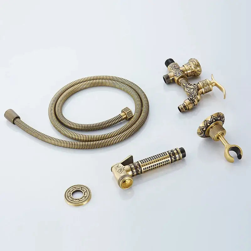 Decorbites™ antique brass wall mounted bidet faucet with ornate detailing and coiled hose for hygienic shower use