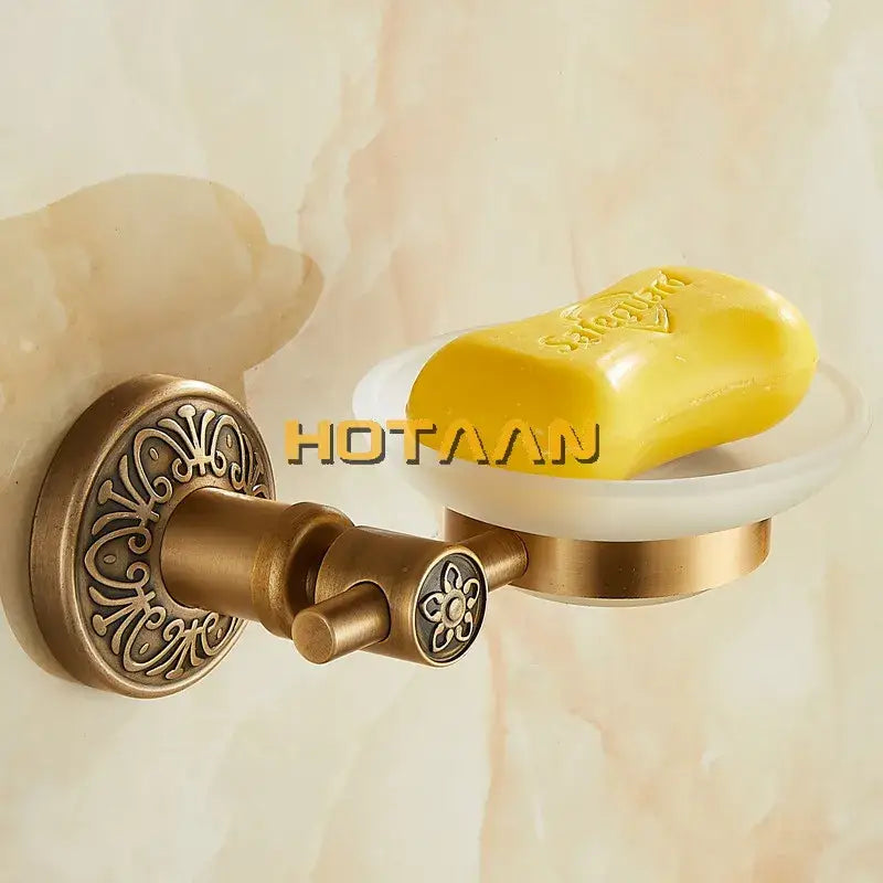 DecorBites antique brass wall mounted soap dish with ornate floral detailing and clear acrylic bowl holding yellow soap