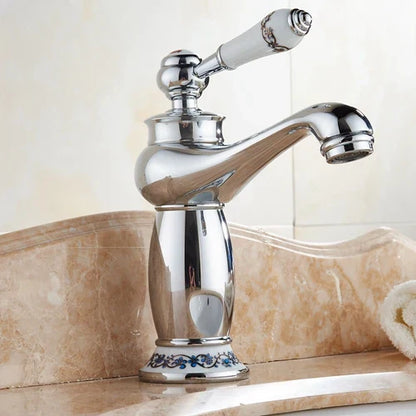 Antique bronze decorbites single handle bathroom faucet with chrome finish white ceramic handle and blue floral detailing real shot details