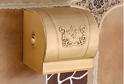 Gold-colored ornate metal toilet paper holder with floral embossing from DecorBites™ antique bathroom accessories set