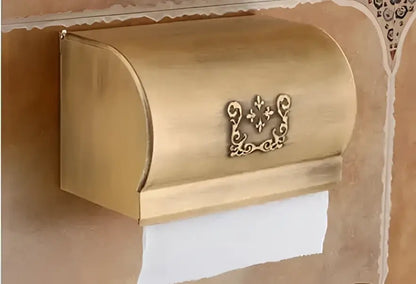 Gold-colored ornate metal toilet paper holder with decorative fleur-de-lis emblem from decorbites bathroom accessories set