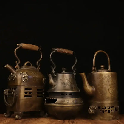 Three antique brass warm wine pots with wooden handles and intricate engraved dragon and floral designs from decorbites