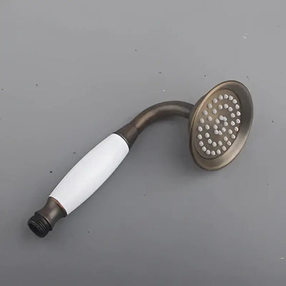 Decorbites antique handheld shower head in antique brass with white ceramic handle and circular spray face