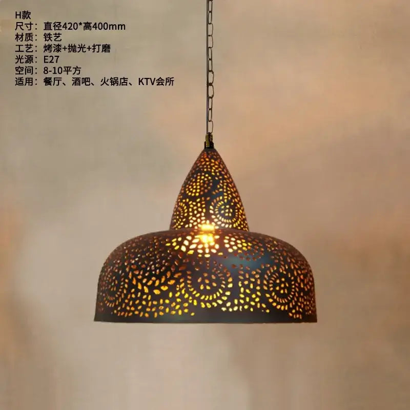 A warm-toned decorbites antique hollow carving pendant light with intricate iron piercing and conical top and domed base