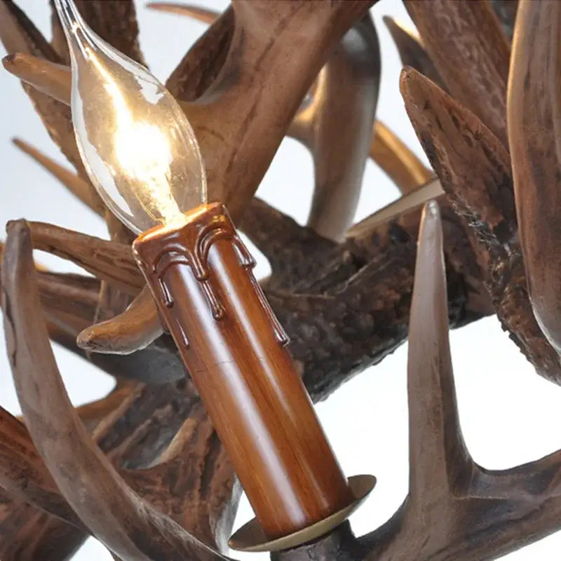 Candle-style bulb with warm glow in polished brown holder resembling wax drips on decorbites antique resin antler chandelier
