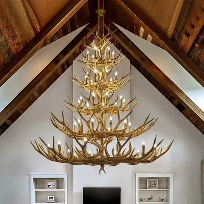 DecorBites antler chandelier with golden-brown resin deer horn tiers holding lit candle-style bulbs for home lighting