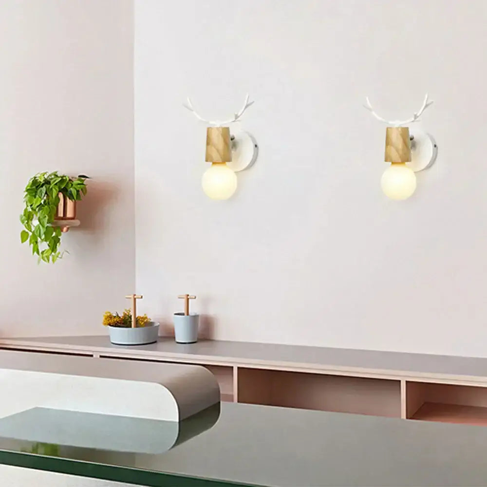 Pair of decorbites antlers vintage wall sconces with white antler tops and warm wood accents housing glowing bulbs