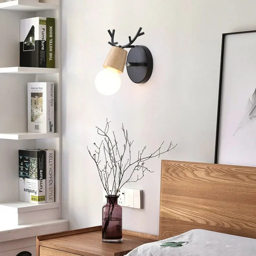 Black and wood DecorBites antlers vintage wall sconce with warm glowing bulb for indoor lighting fixture