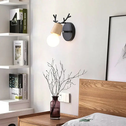 Black and wood DecorBites antlers vintage wall sconce with warm glowing bulb for indoor lighting fixture