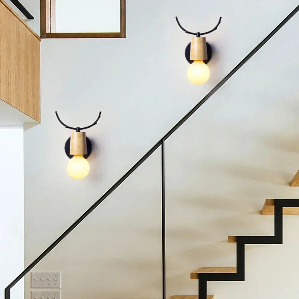 Minimalist decorbites antlers vintage wall sconce with black metal antler arm and light wood base featuring exposed bulb