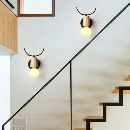 Minimalist decorbites antlers vintage wall sconce with black metal antler arm and light wood base featuring exposed bulb