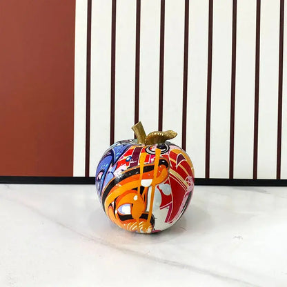 A vibrant glossy decorbites apple figurines art ornament with gold stem and colorful graffiti design for home office decor