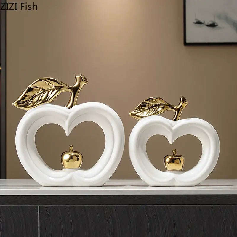 Decorbites apple sculpture featuring white ceramic apples with gold leaf accents and miniature golden apples inside