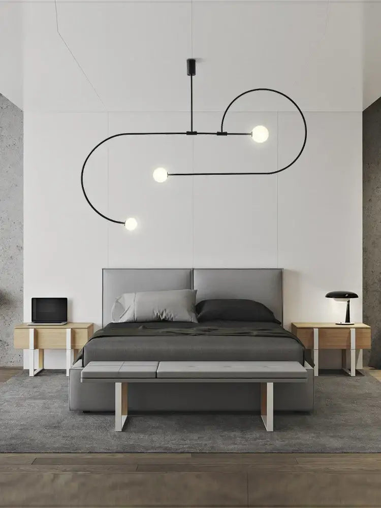 Black curved line pendant light with three spherical bulbs in the DecorBites Arc Line chandelier for living spaces