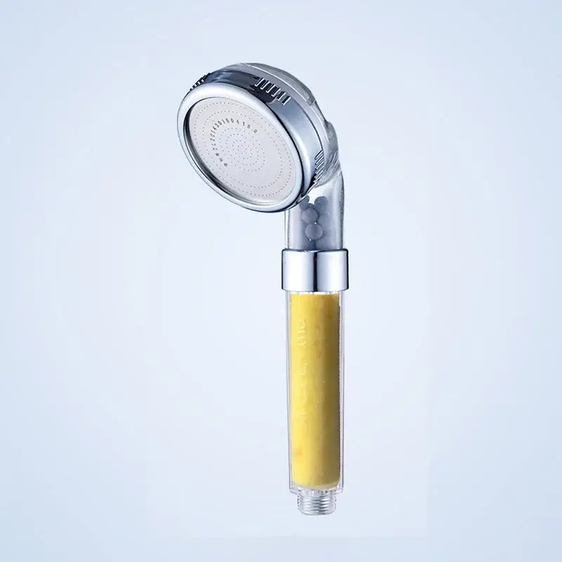 Silver-finished DecorBites Aroma Filter shower head with transparent filter housing containing yellow aroma filter vitamin media
