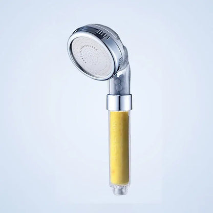 Silver-finished DecorBites Aroma Filter shower head with transparent filter housing containing yellow aroma filter vitamin media