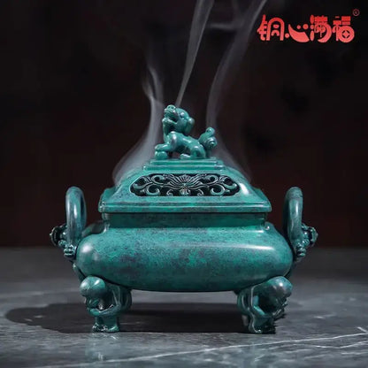 A teal-green bronze aromatherapy brass incense stove with lion-shaped handles and an ornate carved lid by decorbites
