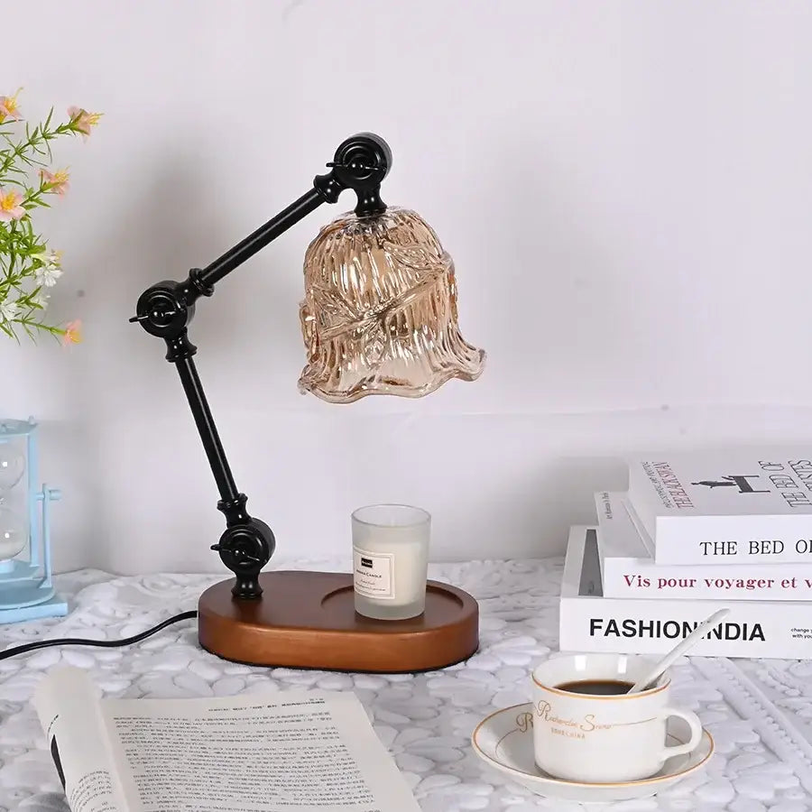 The DecorBites™ wax melting lamp features a vintage black metal arm with an amber glass shade on a wooden base