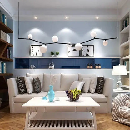 A sleek decorbites art deco pendant light with black branch-like metal frame and white glass spherical bulbs with g9