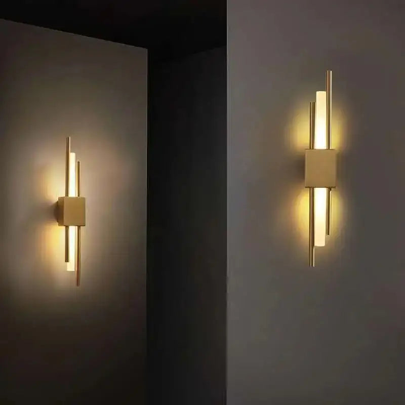 Modern gold-toned wall sconce with marble accent and geometric frosted glass panels by DecorBites Art Deco