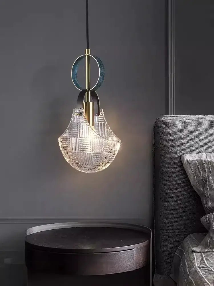 A modern pendant light with a clear woven glass shade and brass accents from decorbites art deco led collection