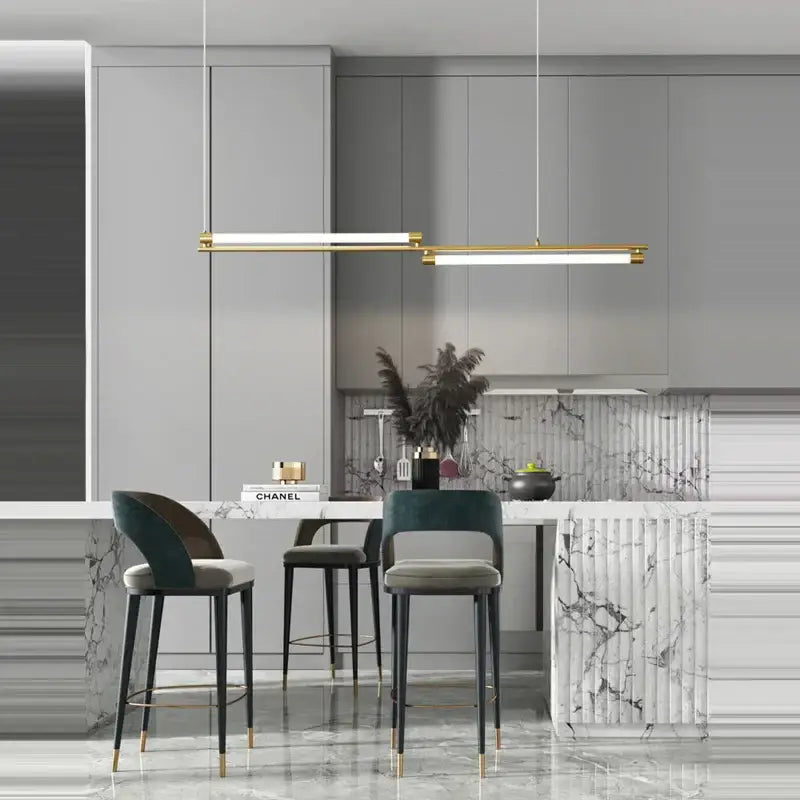 Modern gold-toned decorbites art deco led linear pendant light with minimalist design above marble kitchen island