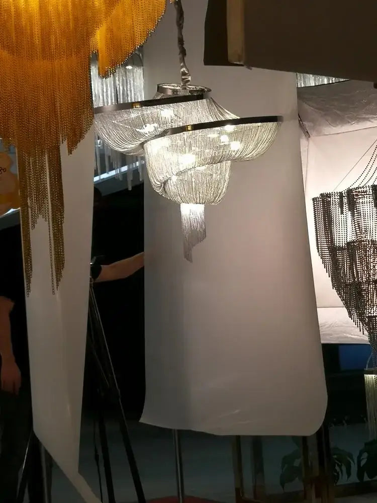 A decorbites art deco multi-tiered chandelier with cascading crystal strands and sleek aluminum frame lighting suspension
