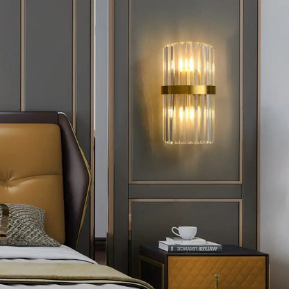 Decorbites art deco led stainless steel crystal wall sconce with gold band emitting warm light on dark wall