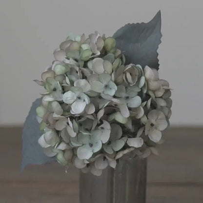 Decorbites artificial hydrangea silk flower arrangement in muted greens and whites in a simple cylindrical vase