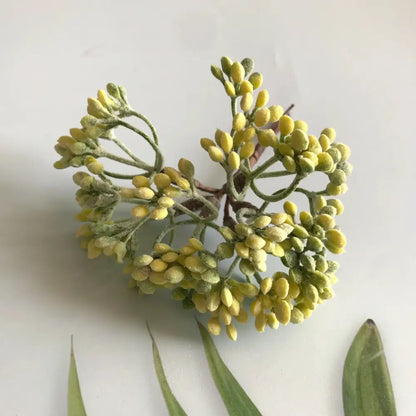 A cluster of yellow artificial blossoms with fuzzy green stems from decorbites artificial plants dried plants diy garland craft