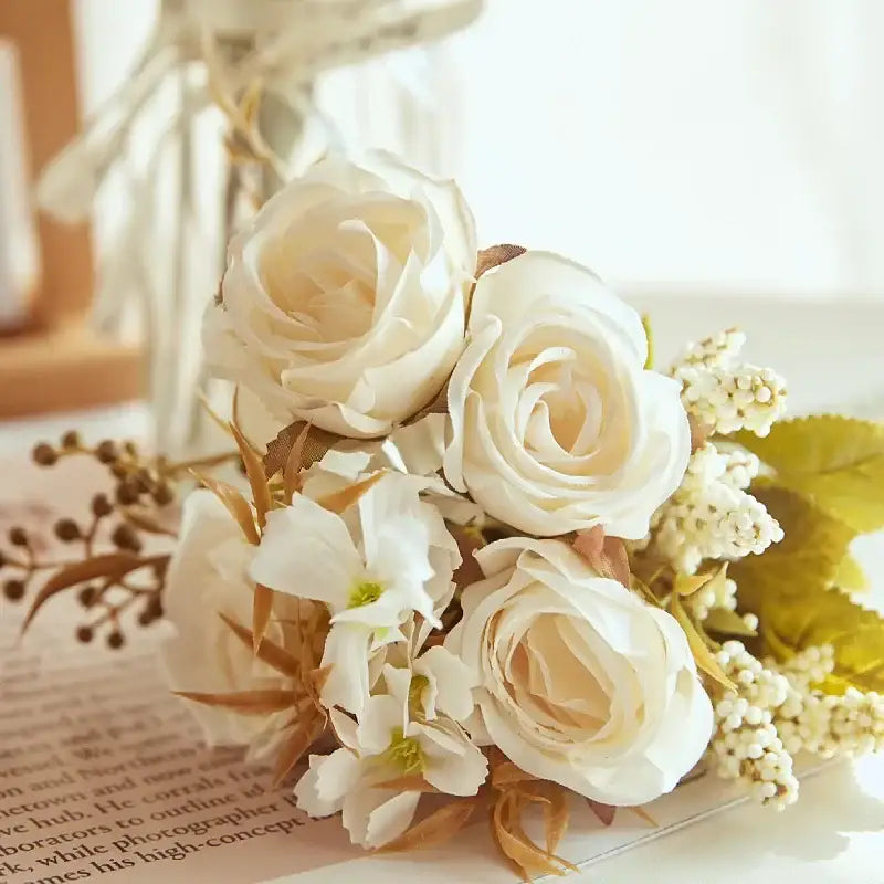 A delicate cream-colored decorbites artificial western rose bouquet with white blossoms and dried stems for wedding decor