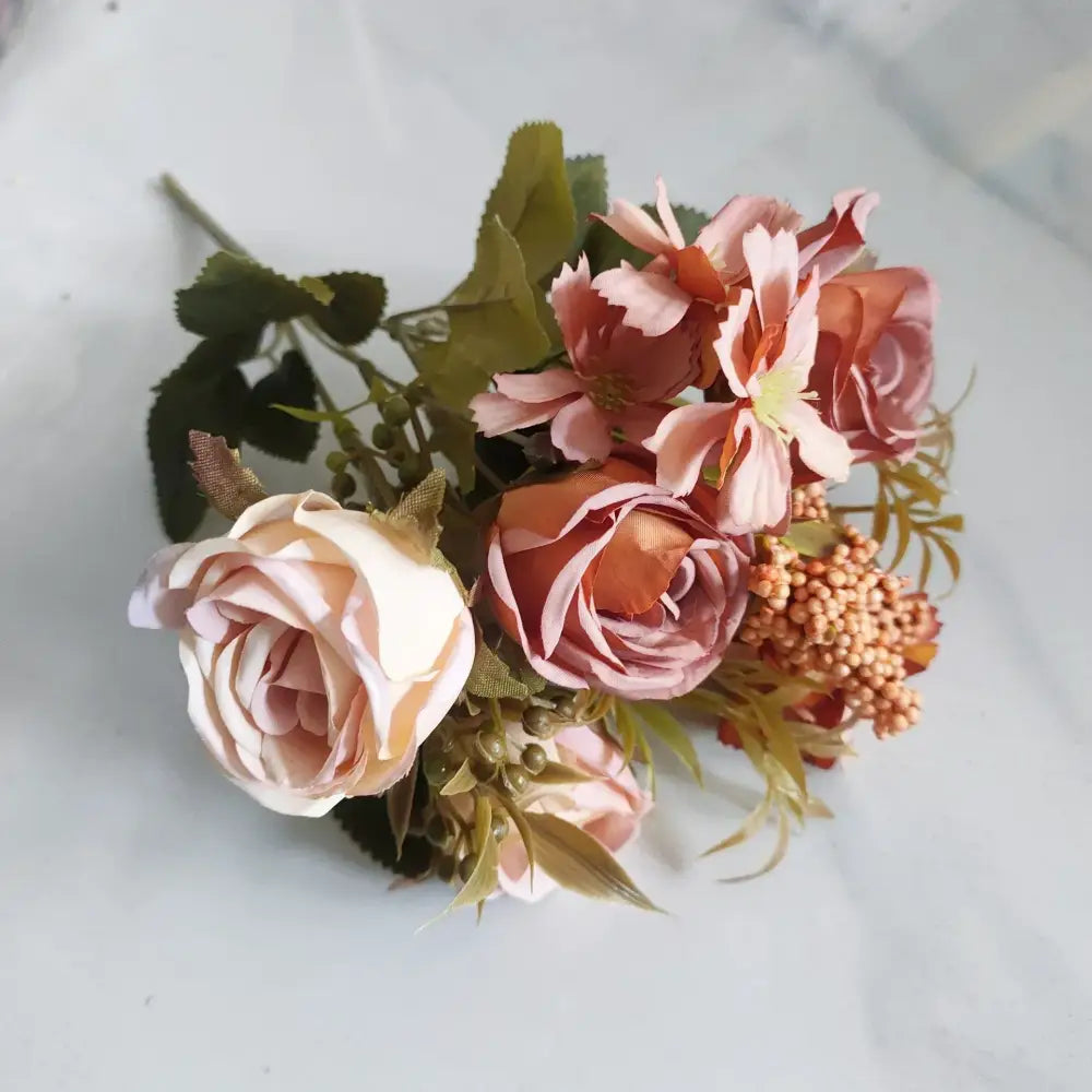 A delicate decorbites artificial western rose bouquet with soft peach blush tones and green foliage for wedding decor