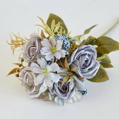 A delicate decorbites artificial western rose bouquet in soft gray white with roses clematis and blue berries for wedding decor