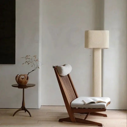 Minimalist wooden lounge chair with slatted back and off-white upholstered seat near decorbites artistic floor lamp