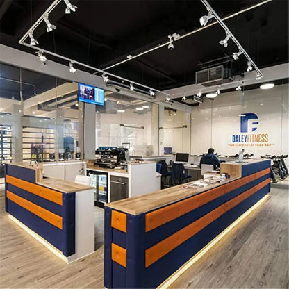 Modern reception desk with navy blue and orange striped panels, wooden countertop, and decorbites artwork led track lighting fixture
