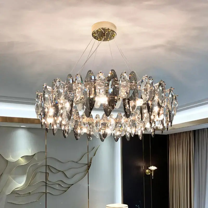 A modern two-tiered decorbites ash crystal ceiling chandelier with faceted glass pieces and gold-toned mount