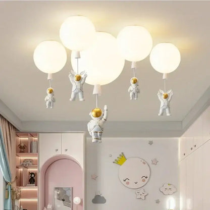 White astronaut-themed decorbites astronaut balloon ceiling light fixture with golden helmets and spherical bulbs for kids room