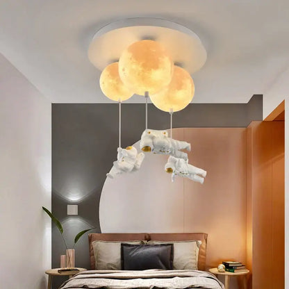 Three glowing textured moon-shaped lights hang from a ceiling fixture above astronauts in white spacesuits decorbites astronaut bubble chandelier