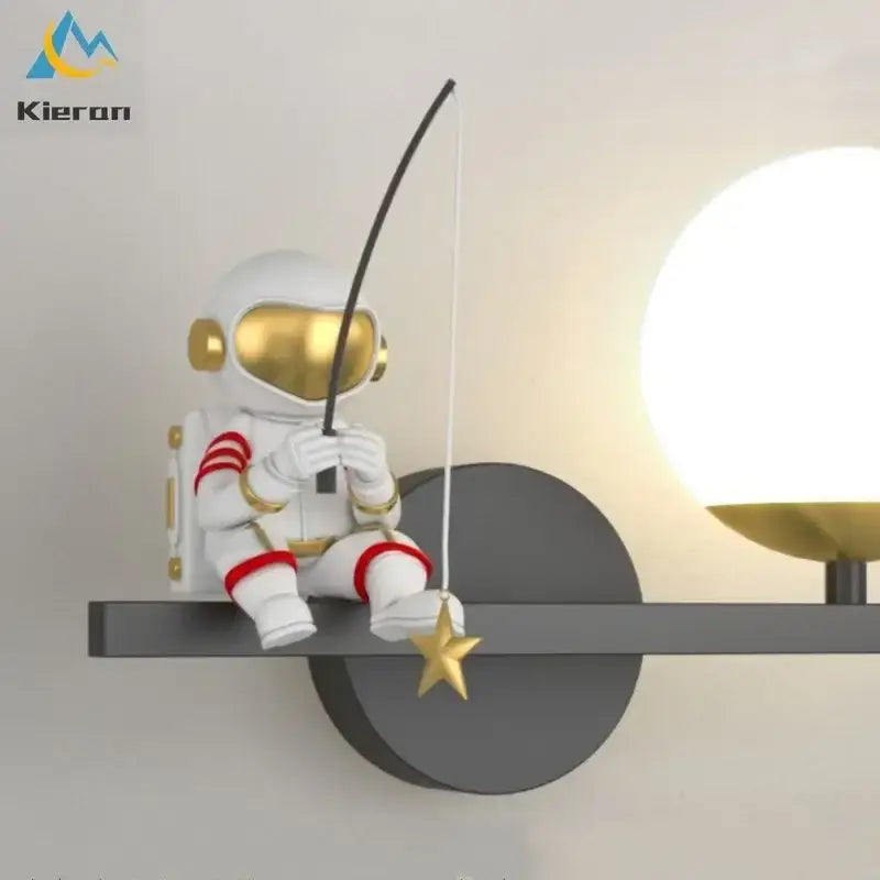 White and gold DecorBites astronaut led wall lamp with red accents holding a fishing rod and golden star for modern decor