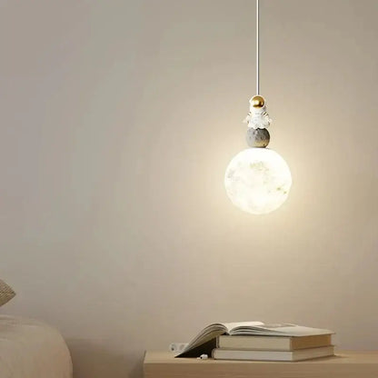 A delicate white and gold decorbites astronaut lunar pendant light features a translucent moon-shaped fixture for modern decor