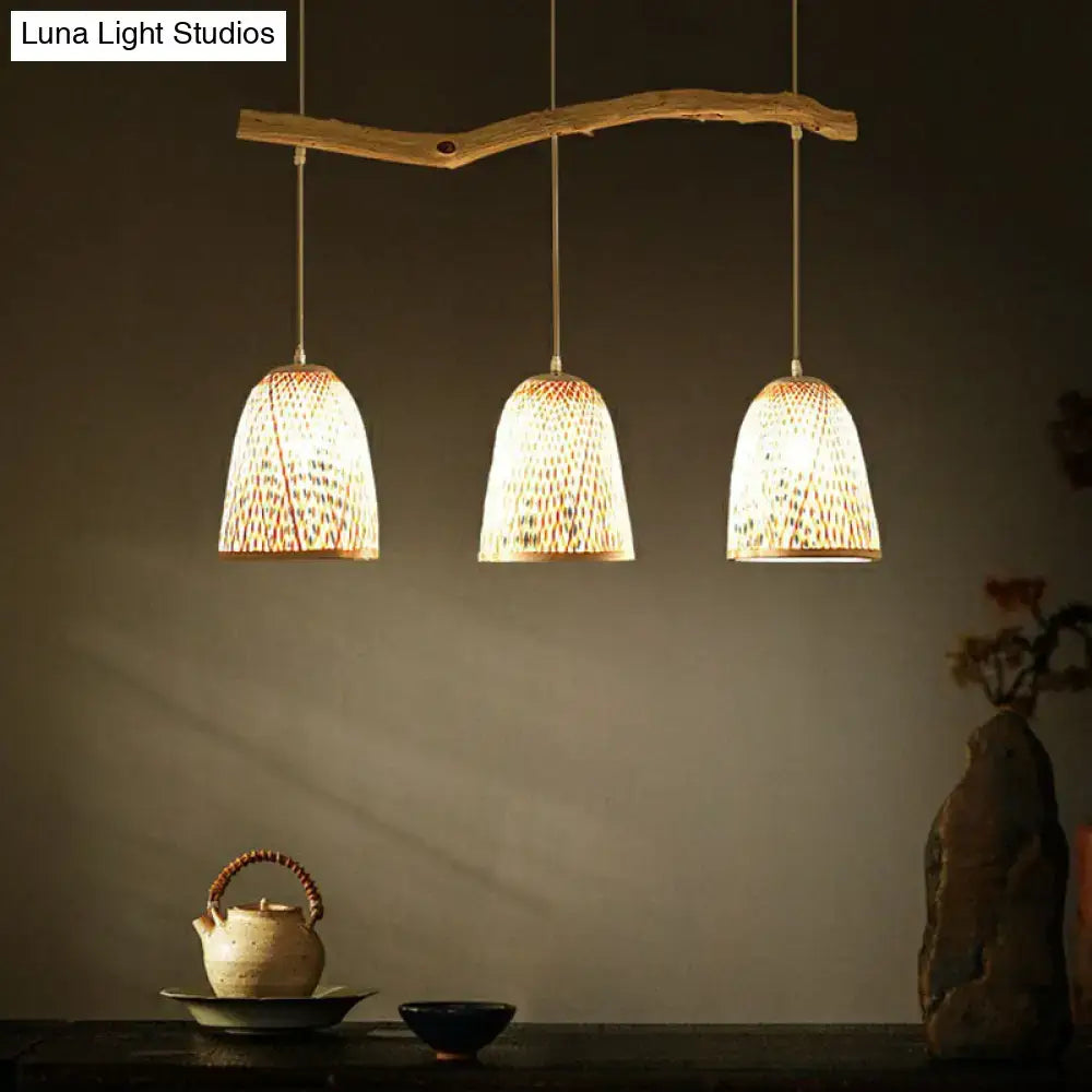 Three warm-toned woven bamboo bell shade pendant lights hang from a rustic wooden branch in wood finish