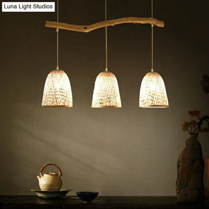 Three warm-toned woven bamboo bell shade pendant lights hang from a rustic wooden branch in wood finish