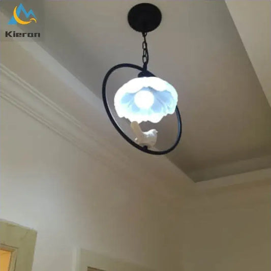 Black metal ring pendant light with frosted glass shade and white ceramic bird in decorbites birdcage led chandelier