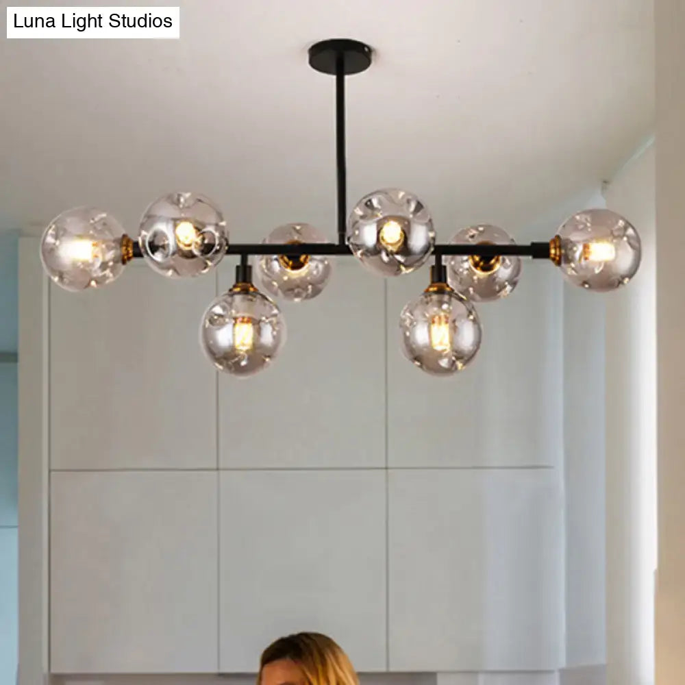 Decorbites black dimpled glass ball pendant light with black metal chandelier, clear glass globe bulbs, and brass accents