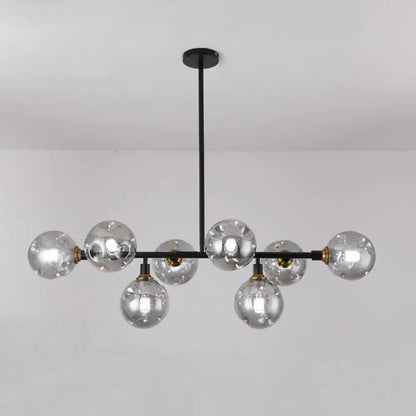 Modern black metal chandelier light type with clear glass globe bulbs and brass accents for dining room island lighting
