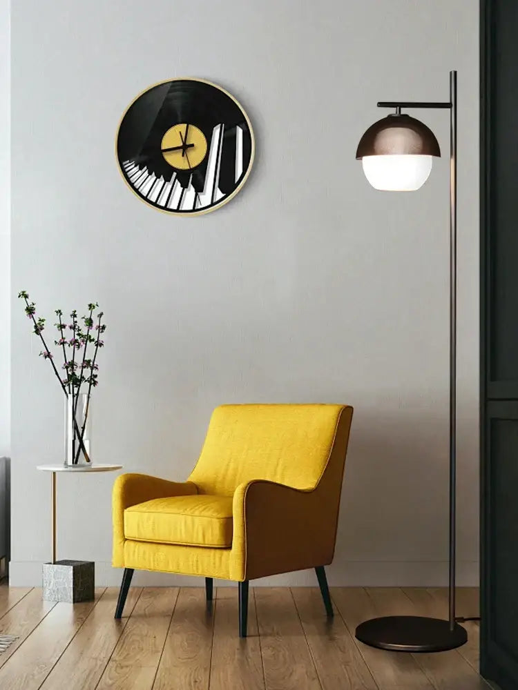 Yellow upholstered armchair beside decorbites black glass ball floor lamp with minimalist nordic design for living room lighting