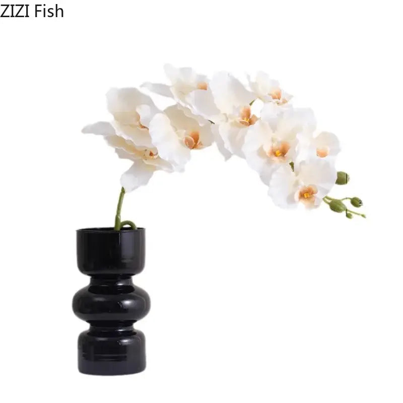 A decorbites black glass vase in sleek black ceramic with artificial white orchid flowers for minimalist room decor